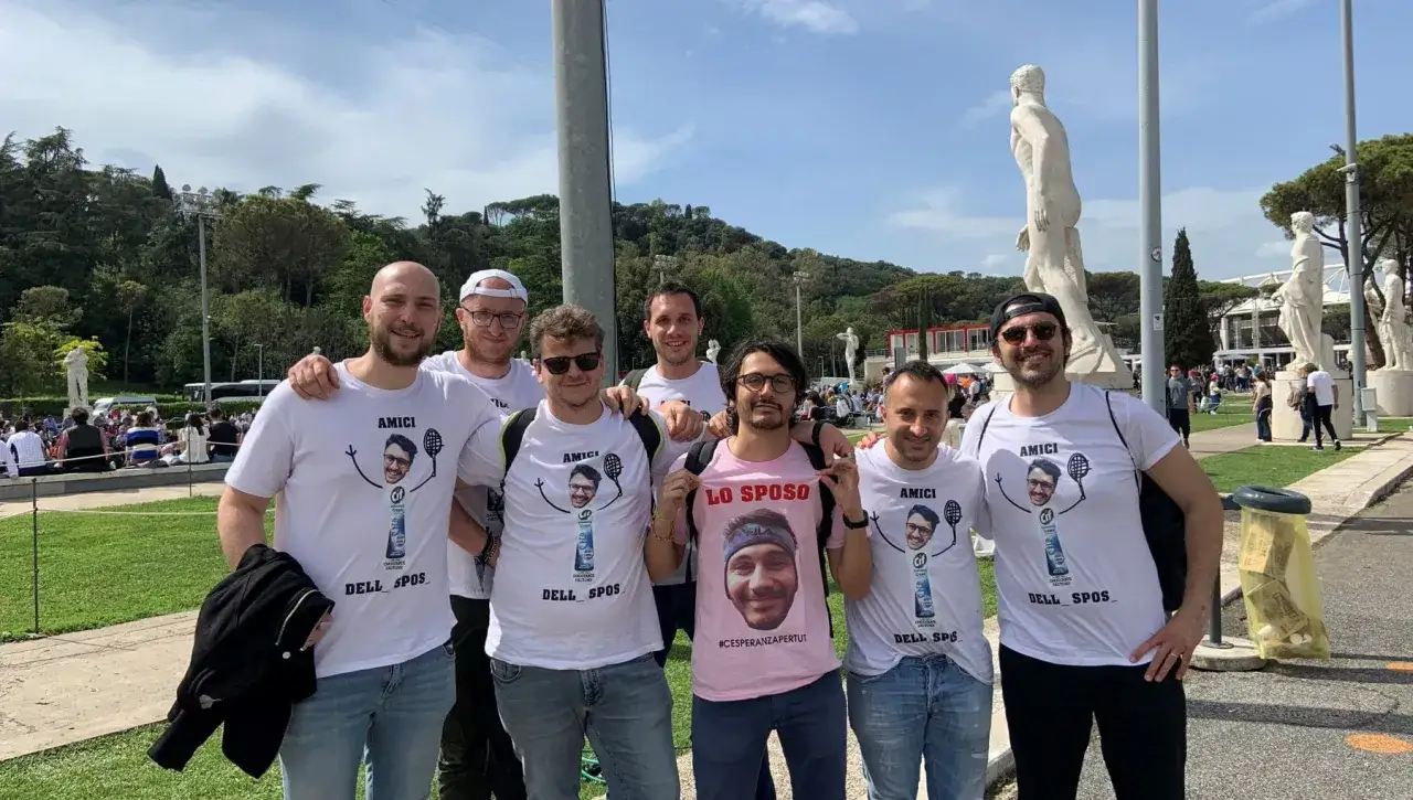 Amici festeggiano l'addio al celibato del futuro sposo, con magliette personalizzate che ritraggono il suo volto.