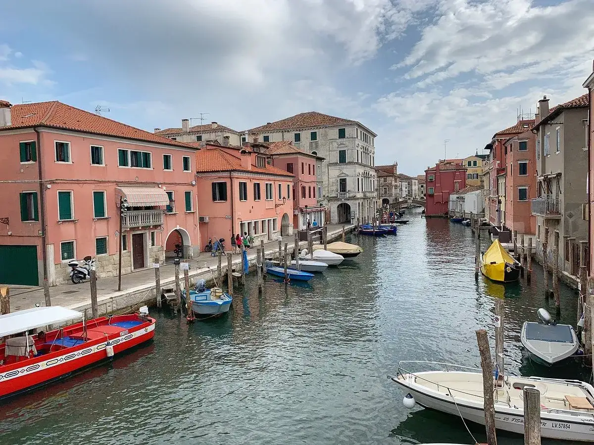 Chioggia cosa vedere: case colorate e canali con barche, un'atmosfera veneziana autentica.