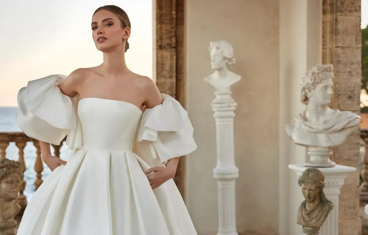 Una sposa in abito bianco con maniche a sbuffo, un'icona di eleganza. Il suo significato è la promessa di un futuro radioso.