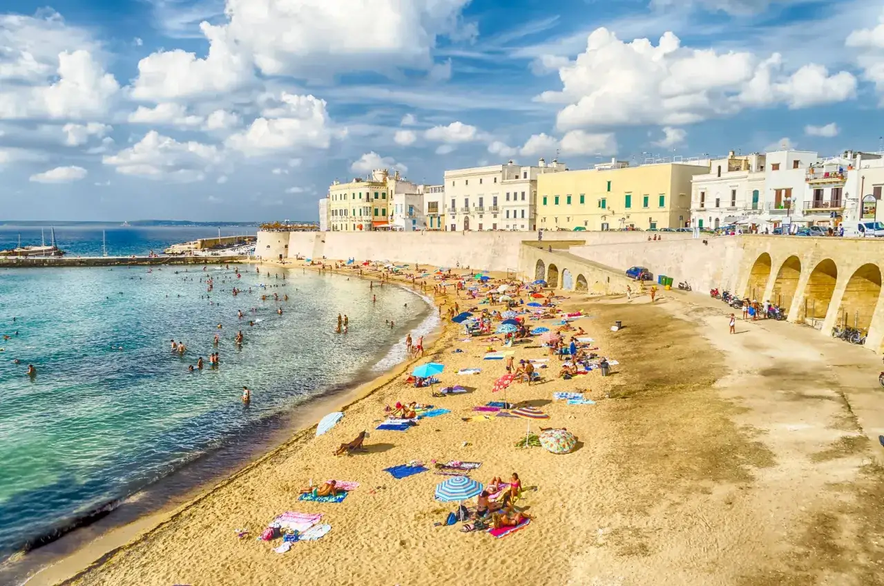 Spiaggia affollata e mare cristallino a Gallipoli. Perfetto per scoprire cosa fare a Gallipoli: nuotare, prendere il sole e godersi la vita.