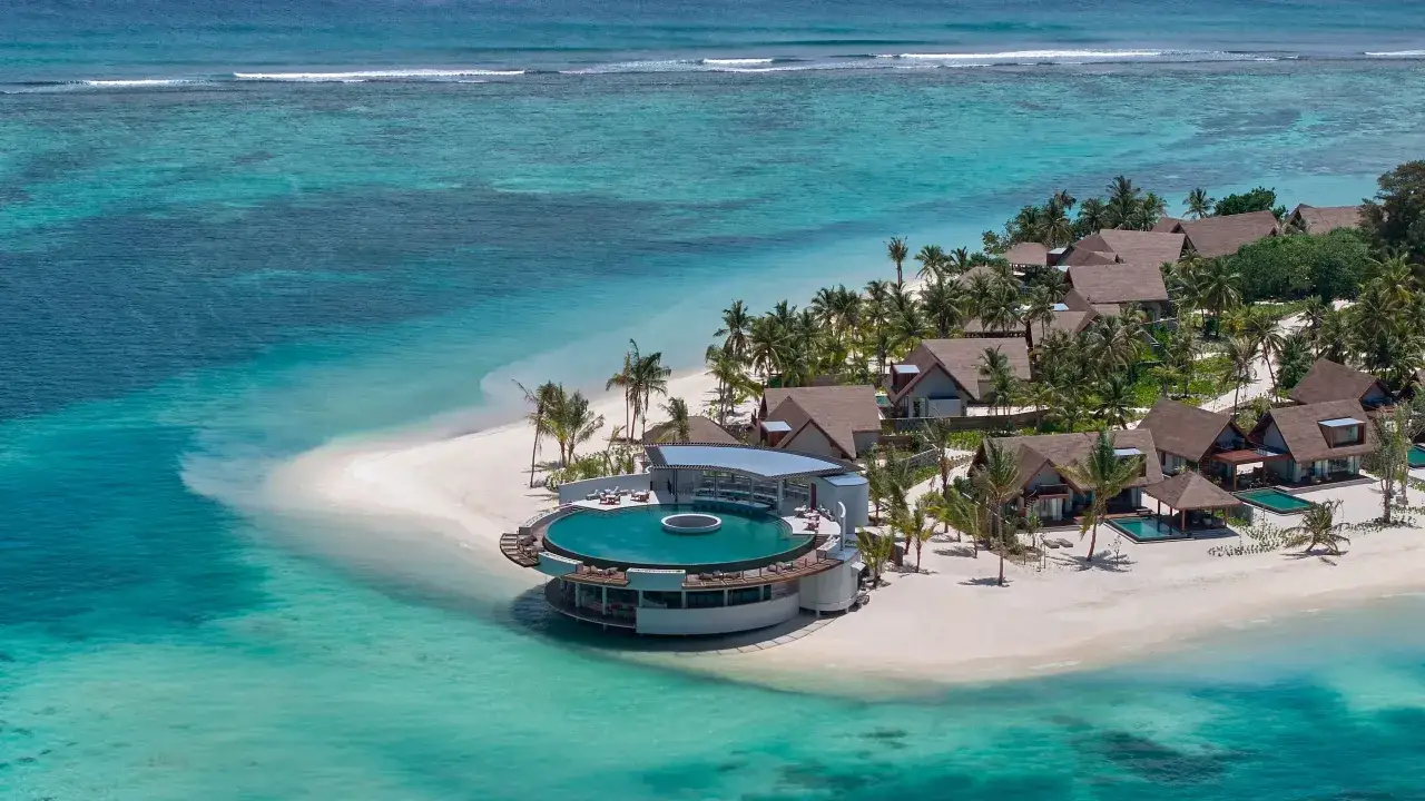 Resort di lusso con piscina a sfioro e ville private su una spiaggia bianca, circondato da acque turchesi. Nonostante la bellezza, questo è il maldive periodo peggiore per visitarlo.