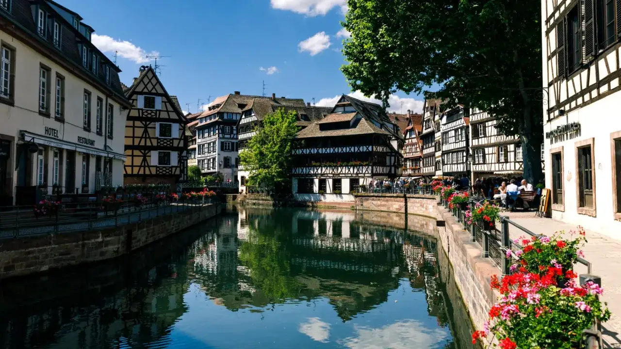 Canali e case a graticcio a Strasburgo, un'idea di cosa vedere a Strasburgo in un giorno. Fiori colorati adornano il lungofiume.
