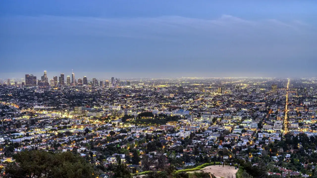 Vista panoramica di Los Angeles illuminata di notte. Un'infinit&agrave; di luci urbane si estende all'orizzonte, con grattacieli che svettano. Perfetto per chi cerca dove dormire a Los Angeles.