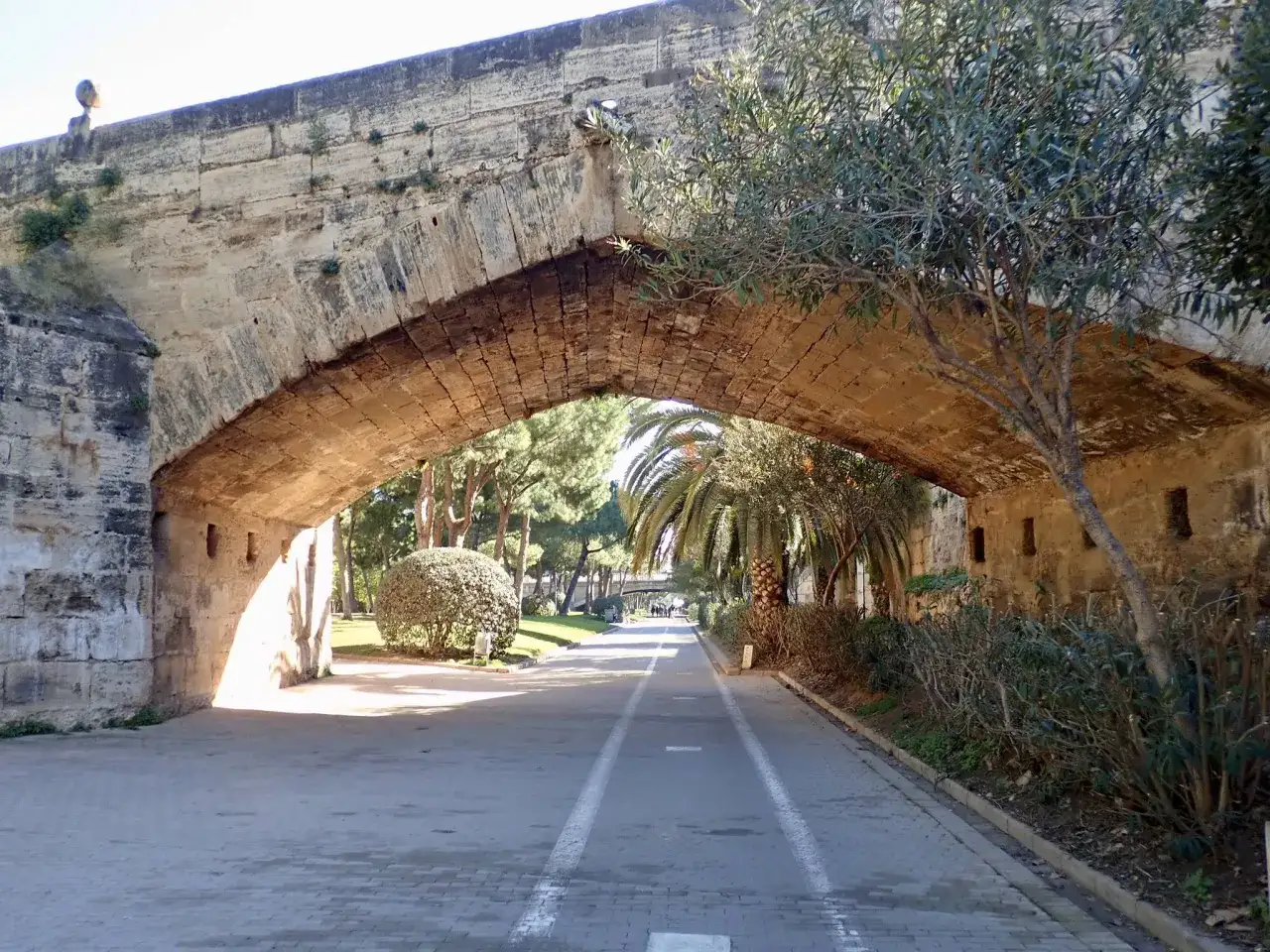 Un antico arco di pietra a Valencia, con un percorso ciclabile che invita a scoprire la città. Come muoversi a Valencia è facile e piacevole.
