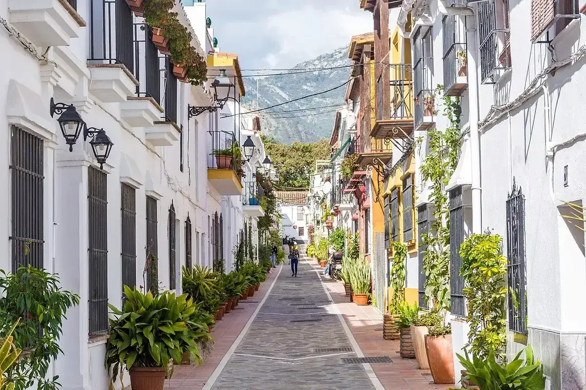 Un vicolo pittoresco con case bianche e colorate, balconi fioriti e piante in vaso. Un assaggio di cosa vedere a Marbella, tra fascino e tradizione.