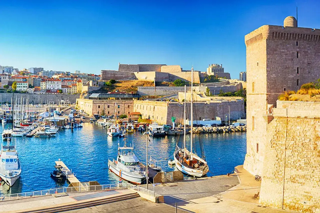 Porto di Marsiglia con barche e fortezze storiche, ideale per scoprire cosa vedere a Marsiglia in crociera.