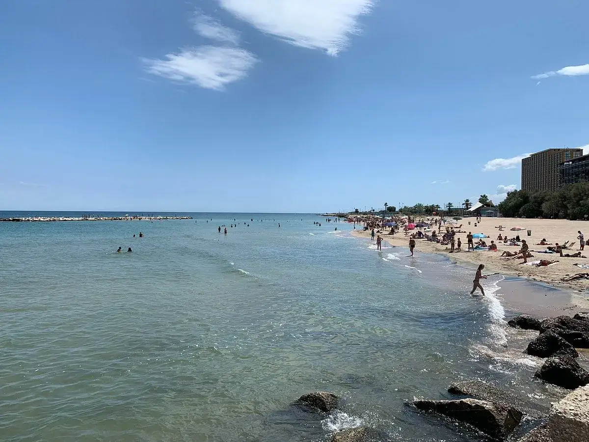 Spiaggia affollata a Bari, ideale per scoprire cosa vedere a Bari in 3 giorni. Gente che prende il sole e nuota.