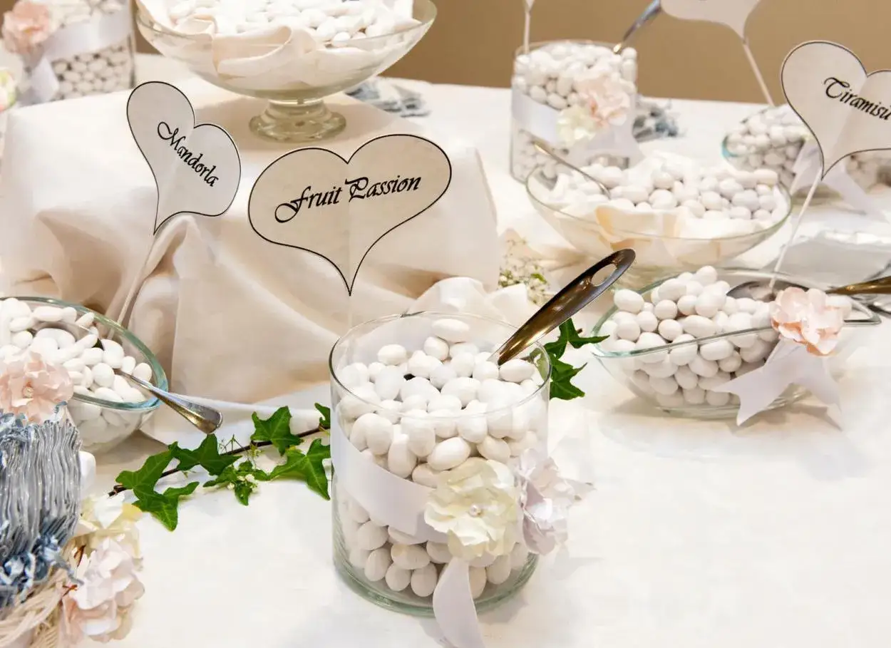 Confetti bianchi in ciotole di vetro, con cartellini a forma di cuore che indicano 