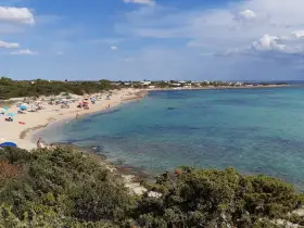 Spiaggia di Punta Prosciutto, Salento. Acque cristalline e sabbia dorata, ideale per una vacanza. Prezzi accessibili per godersi il mare.