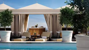 Rilassati in piscina a Los Angeles. Due lettini prendisole e alberi in vaso creano un'oasi perfetta per sapere dove dormire a Los Angeles.