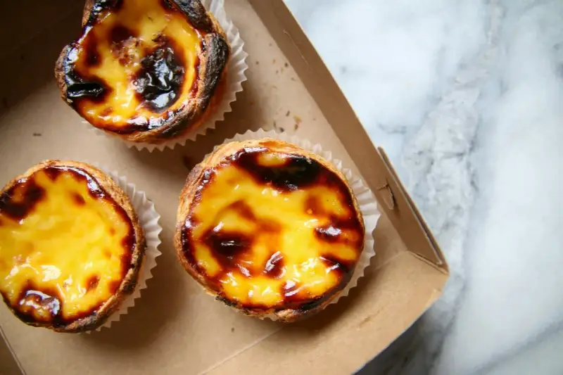 Pastéis de nata appena sfornati, un must per scoprire cosa mangiare a Lisbona. Croccanti fuori, cremosi dentro.